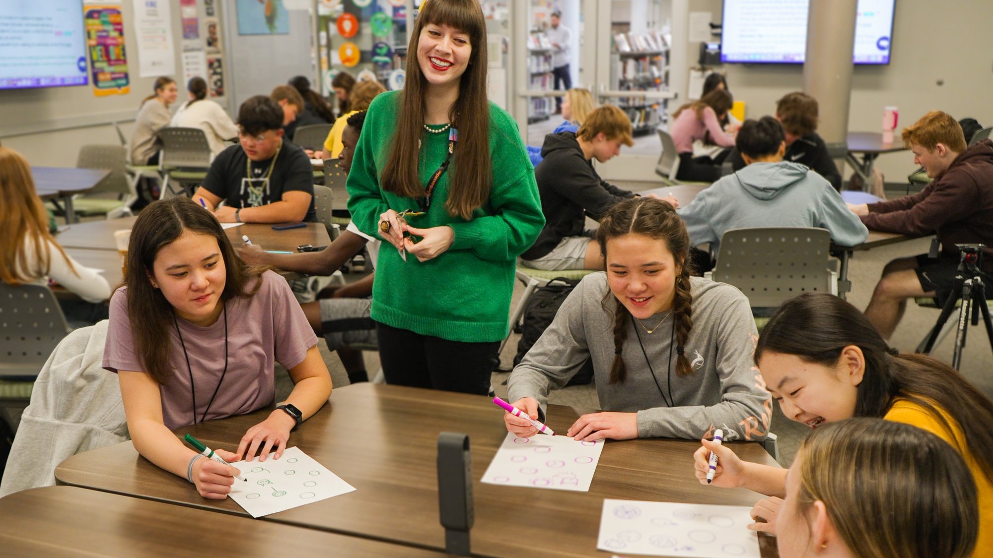Teachers and smiling students doing classwork during advisory period