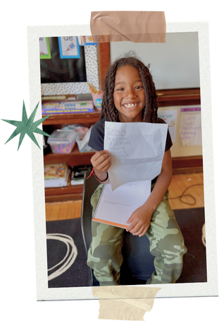 Smiling child working on assignments during advisory period