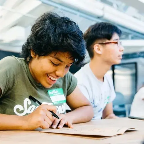 Smiling high school students working on a Wayfinder lesson